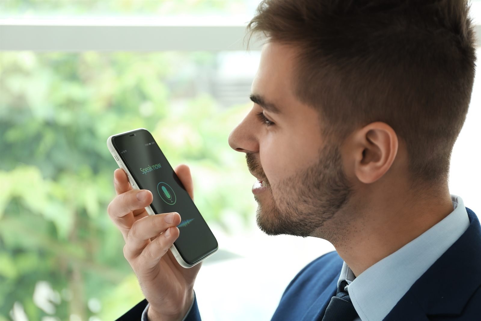 Persoană care folosește comenzi vocale pe telefon pentru o căutare conversațională | GetVizual
