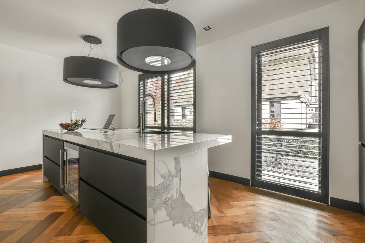 Bucătărie modernă cu insulă centrală și lumină naturală din fereastră | GetVizual
